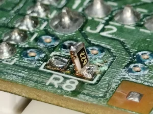 Tombstoning Defects on PCB - Bigmate Philippines Inc. Close-up of a PCB showing tombstoning defects where components are lifted on one end during soldering.